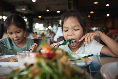 Cute girl having food in restaurant