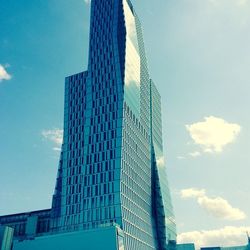 Low angle view of modern building against blue sky