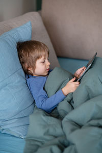 Boy lying on bed at home