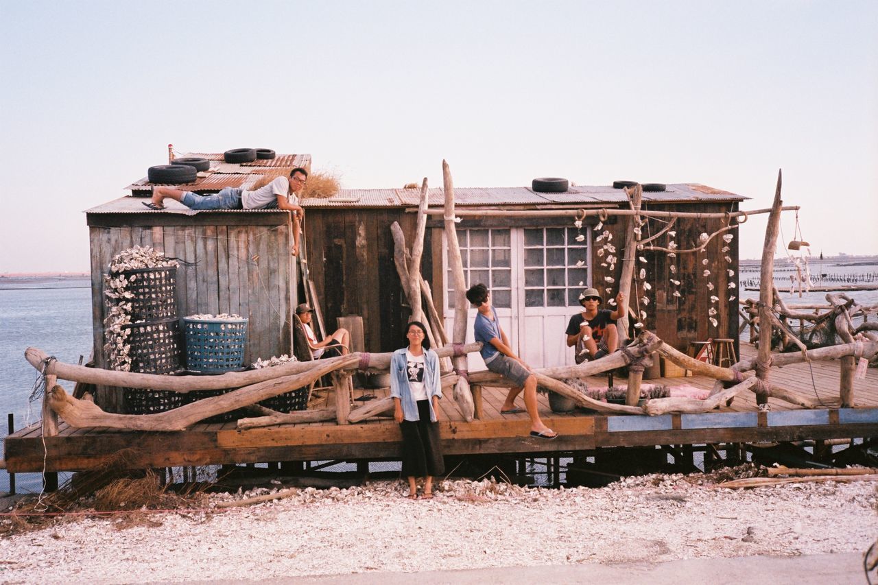 clear sky, built structure, animal themes, building exterior, architecture, beach, sea, sky, nautical vessel, water, day, abandoned, outdoors, transportation, copy space, one animal, wood - material, sand, domestic animals, sitting