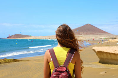 Rear view of woman looking at sea against sky