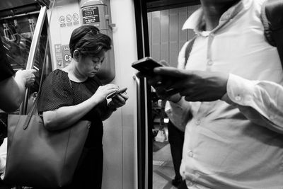 Rear view of man and woman standing by train