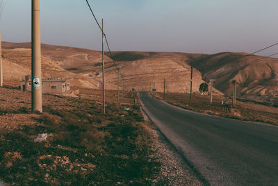 Road leading towards mountains against sky