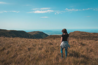 Full length of woman standing on field against sky