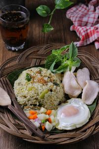 Green fried rice with sunny side up egg, pickles and crackers