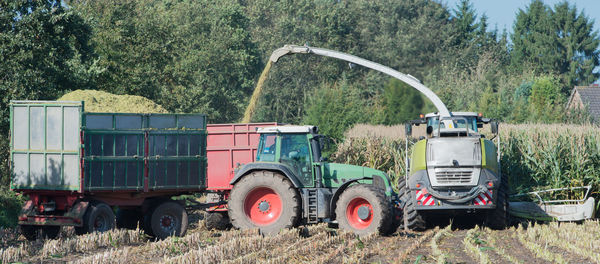 Tractor on field against trees