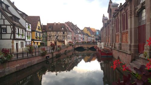 Arch bridge over canal amidst buildings in city