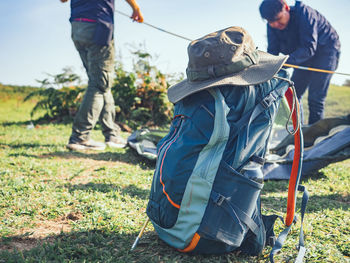 Camping adventure concept from blue hiking backpack and trekking hat.