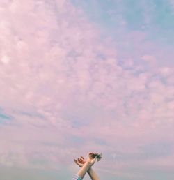 Low angle view of woman hands against sky