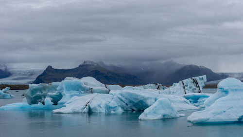 Frozen lake against sky during winter