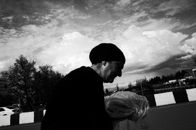 Side view of man standing against sky