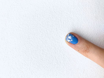 Close-up of hand holding white wall