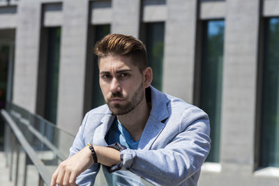 Portrait of young man standing in city