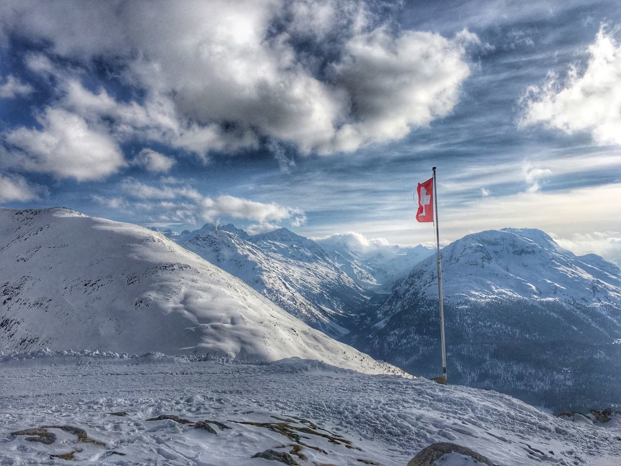 mountain, flag, snow, sky, patriotism, winter, cold temperature, scenics, tranquility, tranquil scene, cloud - sky, identity, national flag, landscape, weather, mountain range, beauty in nature, nature, cloud, snowcapped mountain