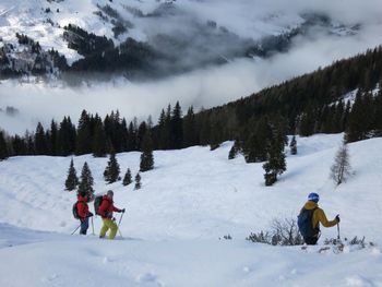 People skiing on snow covered landscape