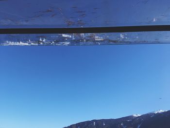 Close-up of snow against clear blue sky