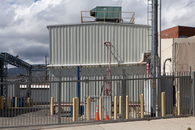 Factory by building against sky