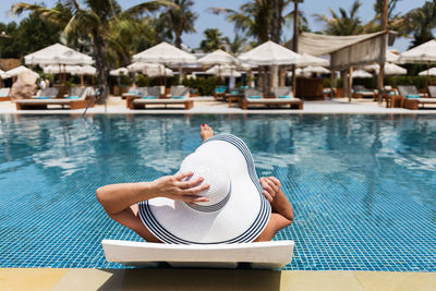 Summer vacation concept. a woman in a hat relaxing at swimming pool.