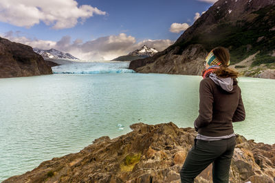 Woman standing on mountain by sea against sky