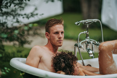 Portrait of shirtless man in bathtub
