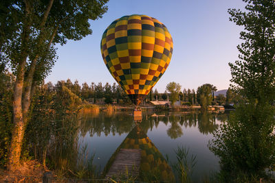 Summer view of hot air balloon flying over lake