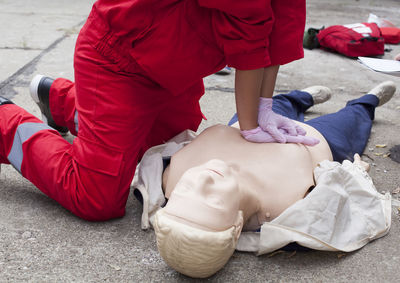 Midsection of paramedic performing cpr on mannequin