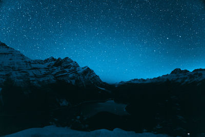 Scenic view of snowcapped mountains against sky at night