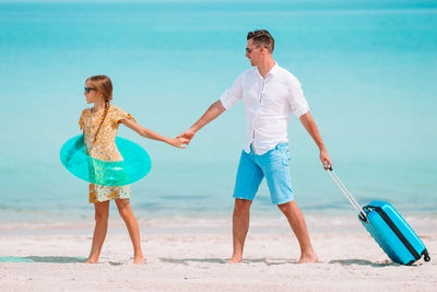 Father and daughter walking on beach