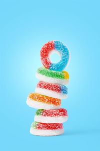 Stack of multi colored candies against blue background