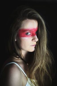 Portrait of beautiful woman against black background