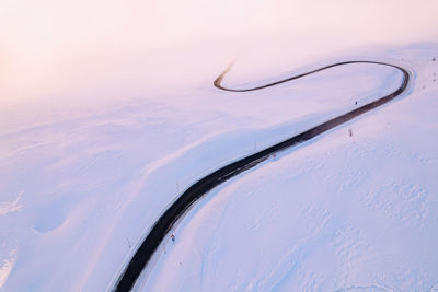 Winding road in the snow that ends in the clouds