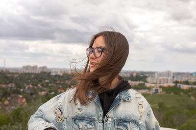 Portrait of young woman wearing hat against sky