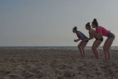 Women bending at beach