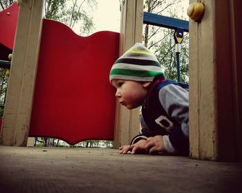 Boy lying on outdoor play equipment