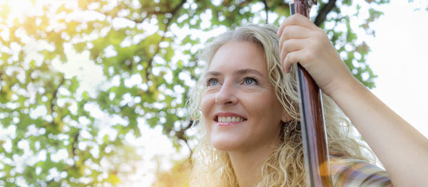 Portrait of a smiling young woman against trees