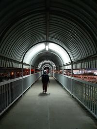 Rear view of man walking in tunnel