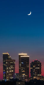 Low angle view of illuminated buildings against sky at night