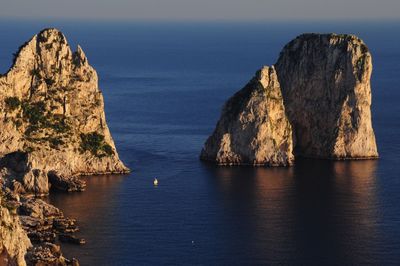 Rock formations in sea against sky