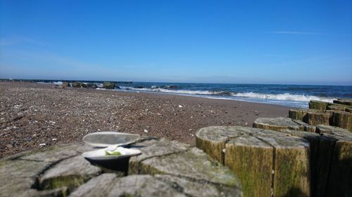 Scenic view of beach against clear blue sky