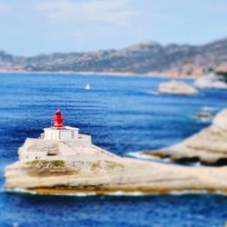 Lighthouse by sea against sky