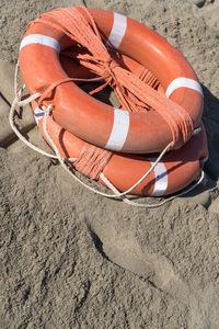 Orange lifebuoys with ropes on the sand