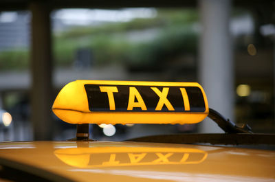 Close-up of yellow sign on car