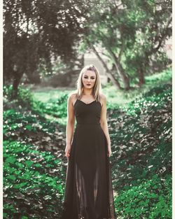 Mid adult woman wearing black dress while standing in park