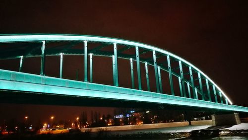 Low angle view of illuminated bridge against sky at night