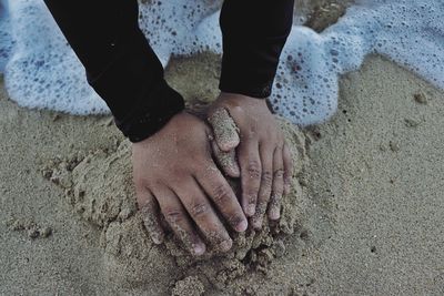 Low section of man on sand at beach