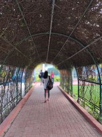 Full length rear view of woman walking on footpath