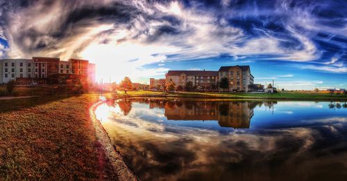 Reflection of buildings in lake at sunset