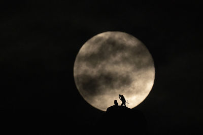 Low angle view of silhouette moon against sky at night