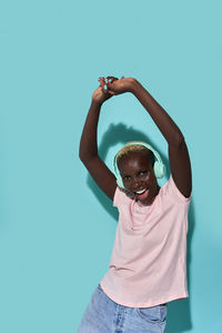 Portrait of boy standing against blue wall