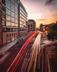 Light trails on road along buildings